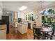 Well-lit kitchen features an island, black appliances, white cabinets, and an adjacent breakfast nook at 5917 Summerston Pl, Charlotte, NC 28277