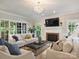 Bright living room with a fireplace, large windows, and comfortable seating arrangement at 5917 Summerston Pl, Charlotte, NC 28277