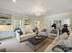 Large, open-concept living room with hardwood floors, built-in shelving, and an abundance of natural light at 5917 Summerston Pl, Charlotte, NC 28277