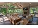 Inviting screened-in porch with an outdoor fireplace, comfortable seating, and ceiling fan at 5917 Summerston Pl, Charlotte, NC 28277