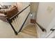 Carpeted staircase with stained handrail and painted risers provides access to lower level at 5917 Summerston Pl, Charlotte, NC 28277