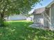 Backyard featuring green grass, a large tree, and a back patio and outbuilding at 6212 Derryfield Dr, Charlotte, NC 28213