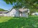 Backyard featuring green grass, a tree, and a back patio next to the home at 6212 Derryfield Dr, Charlotte, NC 28213