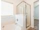 Modern bathroom featuring a bathtub with glass enclosure and a view of the wood-look flooring at 6212 Derryfield Dr, Charlotte, NC 28213