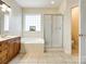 Bright bathroom boasts a large tub, separate shower, and vanity with wood cabinets at 720 Kingsmill Ln, Clover, SC 29710