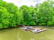 Private boat dock on calm lake, surrounded by trees and lush greenery. For Sale sign included at 720 Kingsmill Ln, Clover, SC 29710