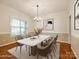 Formally staged dining room features a modern marble table, chandelier, and ample natural light at 720 Kingsmill Ln, Clover, SC 29710