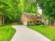 Charming brick home with an attached garage, a well-manicured lawn, and mature trees at 720 Kingsmill Ln, Clover, SC 29710