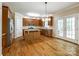 Open kitchen with hardwood floors, stainless steel appliances, an island, and access to the backyard at 720 Kingsmill Ln, Clover, SC 29710