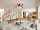 Open living room featuring hardwood floors, a ceiling fan, and view to the kitchen and staircase at 720 Kingsmill Ln, Clover, SC 29710