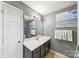 Bathroom featuring a white sink and a black cabinet, with a white door on the left and a beach picture on the wall at 8259 Carob Tree Ln, Charlotte, NC 28215