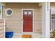 Close-up of a red front door with a decorative round window, offering curb appeal at 8259 Carob Tree Ln, Charlotte, NC 28215