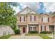 Charming tan two-story townhouse featuring red shutters, landscaped yard, and well-maintained lawn at 8259 Carob Tree Ln, Charlotte, NC 28215