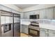 Modern kitchen featuring stainless steel appliances, ample gray cabinets, and bright white countertops at 8259 Carob Tree Ln, Charlotte, NC 28215