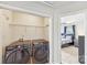 Laundry room featuring black Samsung washer and dryer, with a view into a bedroom with bed and nightstand at 8259 Carob Tree Ln, Charlotte, NC 28215