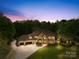 Luxury home at dusk with landscape lighting, large driveway, and stone and stucco exterior at 8451 Ridgewood Rd, Sherrills Ford, NC 28673