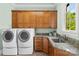 Functional laundry room featuring a washer, dryer, cabinets, granite countertop, and a stainless steel sink at 8451 Ridgewood Rd, Sherrills Ford, NC 28673