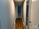 Hallway features durable wood-look flooring and neutral wall tones, connecting various rooms in the home at 9325 Old Concord Rd # D, Charlotte, NC 28213
