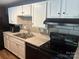 Traditional kitchen featuring white cabinets, dark hardware, black appliances and tile backsplash with laminate countertops at 9325 Old Concord Rd # D, Charlotte, NC 28213