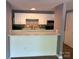 Open kitchen area with white cabinets, and a convenient breakfast bar overlooking the living space at 9325 Old Concord Rd # D, Charlotte, NC 28213