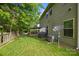 Backyard with lawn, trees, patio, and an AC unit, providing a blend of comfort and functionality at 9437 Tavistock Ct, Matthews, NC 28105