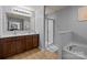 Bathroom offers a double sink vanity, bright shower, and soaking tub at 9437 Tavistock Ct, Matthews, NC 28105