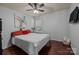 Neutral bedroom with white quilt, hardwood floors, and a ceiling fan at 9437 Tavistock Ct, Matthews, NC 28105