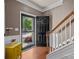 Bright foyer with wood floors, staircase, yellow console, and open view to the outside at 9437 Tavistock Ct, Matthews, NC 28105