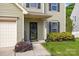Close-up of front entrance featuring black door, house number, and landscaped garden at 9437 Tavistock Ct, Matthews, NC 28105