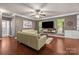 Bright living room showcases hardwood floors, neutral paint colors and media center at 9437 Tavistock Ct, Matthews, NC 28105