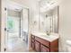 Bright bathroom featuring a large mirror, vanity with dark cabinets, and neutral tile flooring at 1000 E Woodlawn Rd # 408, Charlotte, NC 28209