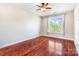 Bright bedroom features a ceiling fan and large window with scenic views and hardwood floors at 1000 E Woodlawn Rd # 408, Charlotte, NC 28209