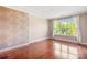 Bright bedroom with hardwood floors, large window, and decorative wallpaper accent wall at 1000 E Woodlawn Rd # 408, Charlotte, NC 28209