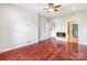 Bright bedroom with hardwood floors, a fan, an electric fireplace, and a doorway to a bathroom at 1000 E Woodlawn Rd # 408, Charlotte, NC 28209