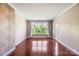 Spacious bedroom featuring hardwood floors, a large window offering natural light, and white trim at 1000 E Woodlawn Rd # 408, Charlotte, NC 28209