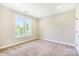Neutral bedroom offers cozy carpet, a window with natural light and a serene atmosphere at 1000 E Woodlawn Rd # 408, Charlotte, NC 28209