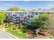Well-maintained apartment building exterior with manicured landscaping and a prominent community sign at 1000 E Woodlawn Rd # 408, Charlotte, NC 28209