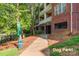 Close up of brick condos showing pet waste station and entryway in park-like setting near dog-friendly area at 1000 E Woodlawn Rd # 408, Charlotte, NC 28209