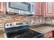 Close-up of kitchen showcasing stainless steel appliances and mosaic tile backsplash at 1000 E Woodlawn Rd # 408, Charlotte, NC 28209