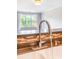 Bright kitchen faucet and backsplash with view of the large window and living area at 1000 E Woodlawn Rd # 408, Charlotte, NC 28209