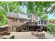 Spacious brick patio backyard with lush greenery, an upper deck, and outdoor seating areas at 10209 Thomas Payne Cir, Charlotte, NC 28277