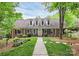 Charming brick home featuring dormer windows, a well-manicured lawn, and a welcoming walkway at 10209 Thomas Payne Cir, Charlotte, NC 28277