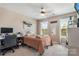 Cozy bedroom featuring plush bedding, a ceiling fan, and natural light at 10436 Dalton Woods Nw Ct, Huntersville, NC 28078