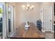 Dining room with wood table, modern chandelier, and sliding glass doors at 10436 Dalton Woods Nw Ct, Huntersville, NC 28078