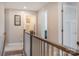 Upstairs hallway with view of bathroom, neutral paint, and wood railing at 10436 Dalton Woods Nw Ct, Huntersville, NC 28078