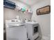 Well-equipped laundry room with modern washer and dryer, ample shelving, and charming decorative wall art at 10436 Dalton Woods Nw Ct, Huntersville, NC 28078