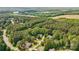 Expansive aerial view of a residential area with lush green trees, several lakes, and a clear blue sky above at 109 Braxton Gate Ct, Mount Holly, NC 28120