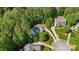 Aerial view showcases a home with a sprawling driveway, mature trees, and manicured lawns at 109 Braxton Gate Ct, Mount Holly, NC 28120