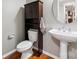 Cozy half-bathroom features a pedestal sink, dark wood cabinet, and a round mirror at 109 Braxton Gate Ct, Mount Holly, NC 28120