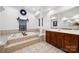 Bright bathroom featuring tile floors, soaking tub, and decorative window at 109 Braxton Gate Ct, Mount Holly, NC 28120